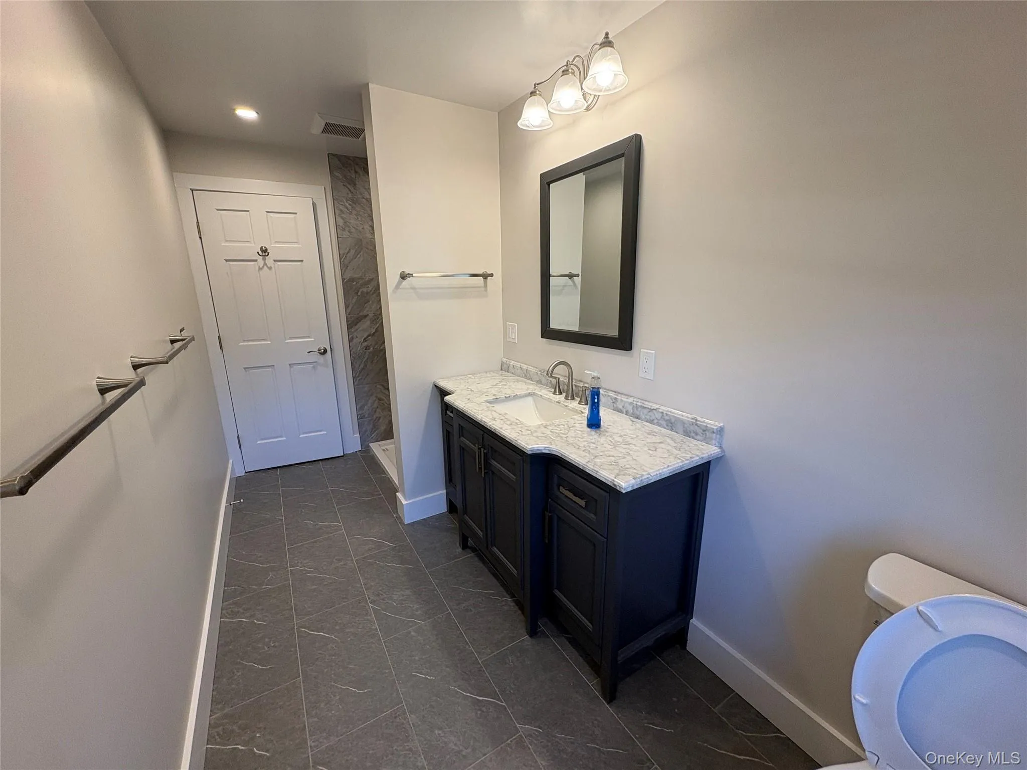 Bathroom with vanity, recessed lighting, and a shower Bathroom with vanity, recessed lighting, and a shower