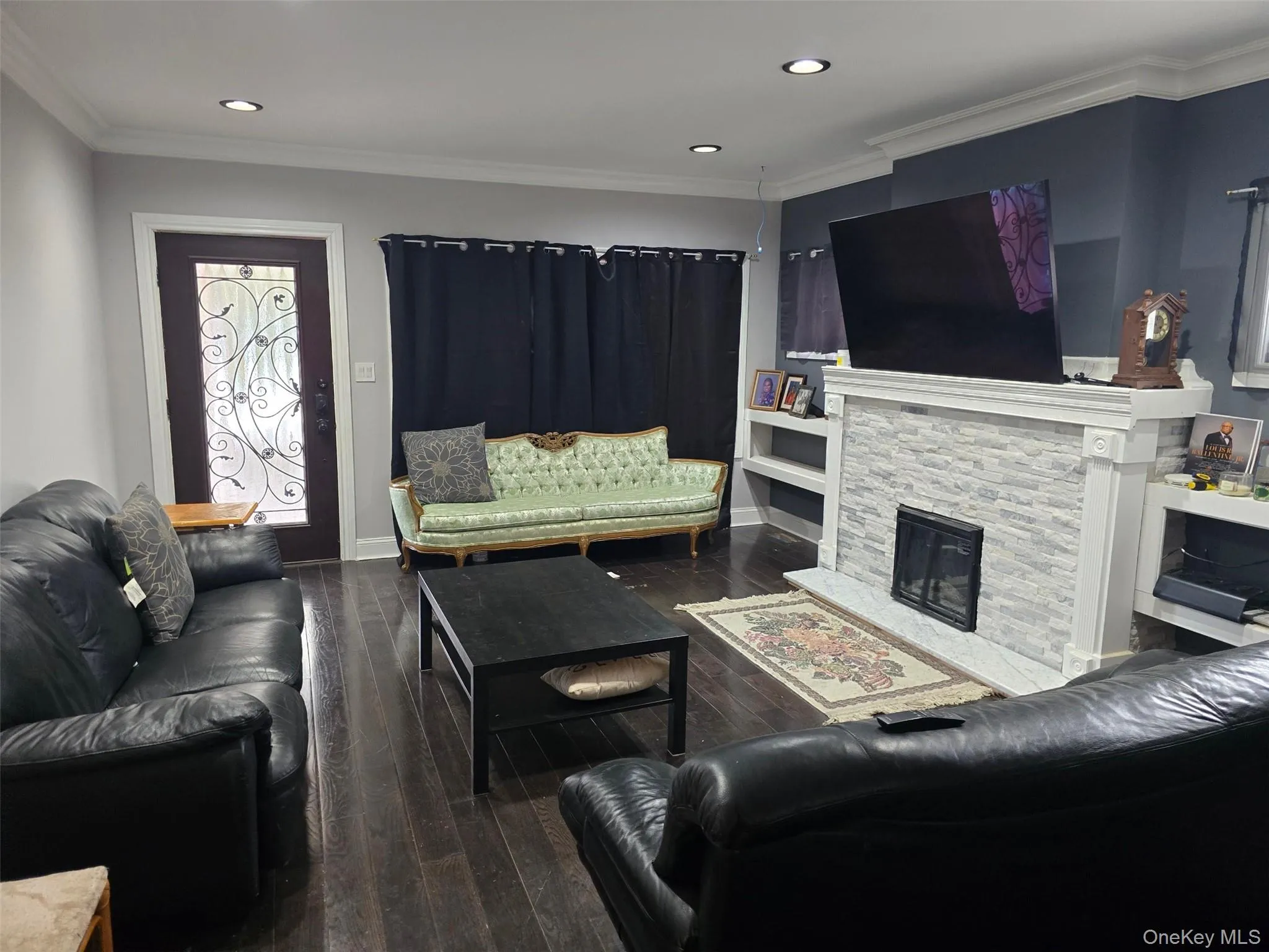 Living room with crown molding, dark wood-type flooring, a fireplace, and recessed lighting Living room with crown molding, dark wood-type flooring, a fireplace, and recessed lighting