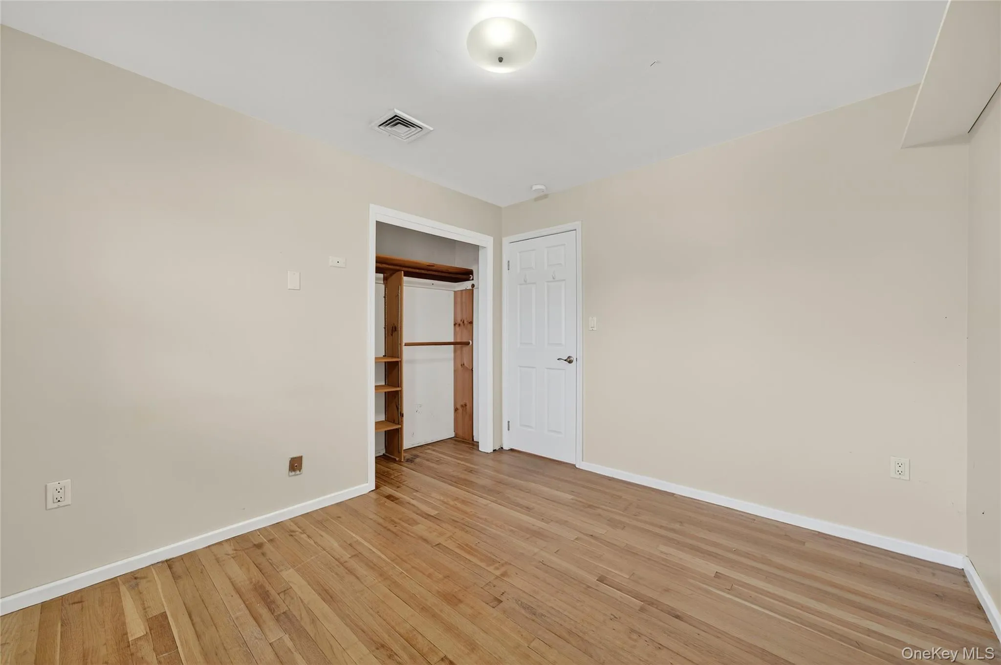 Unfurnished bedroom featuring light wood-style flooring and a closet Unfurnished bedroom featuring light wood-style flooring and a closet