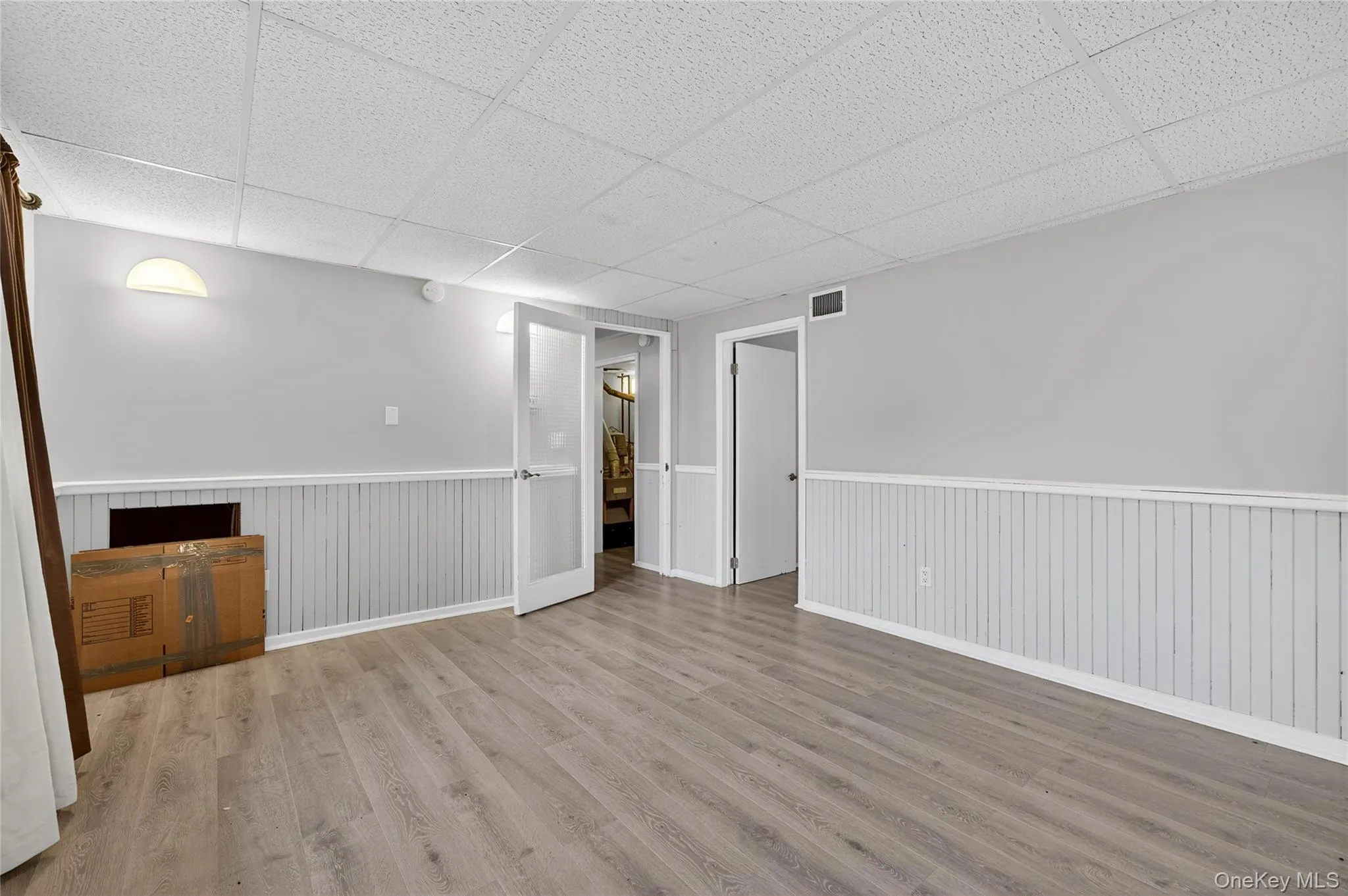Finished basement featuring wood finished floors and a paneled ceiling Finished basement featuring wood finished floors and a paneled ceiling
