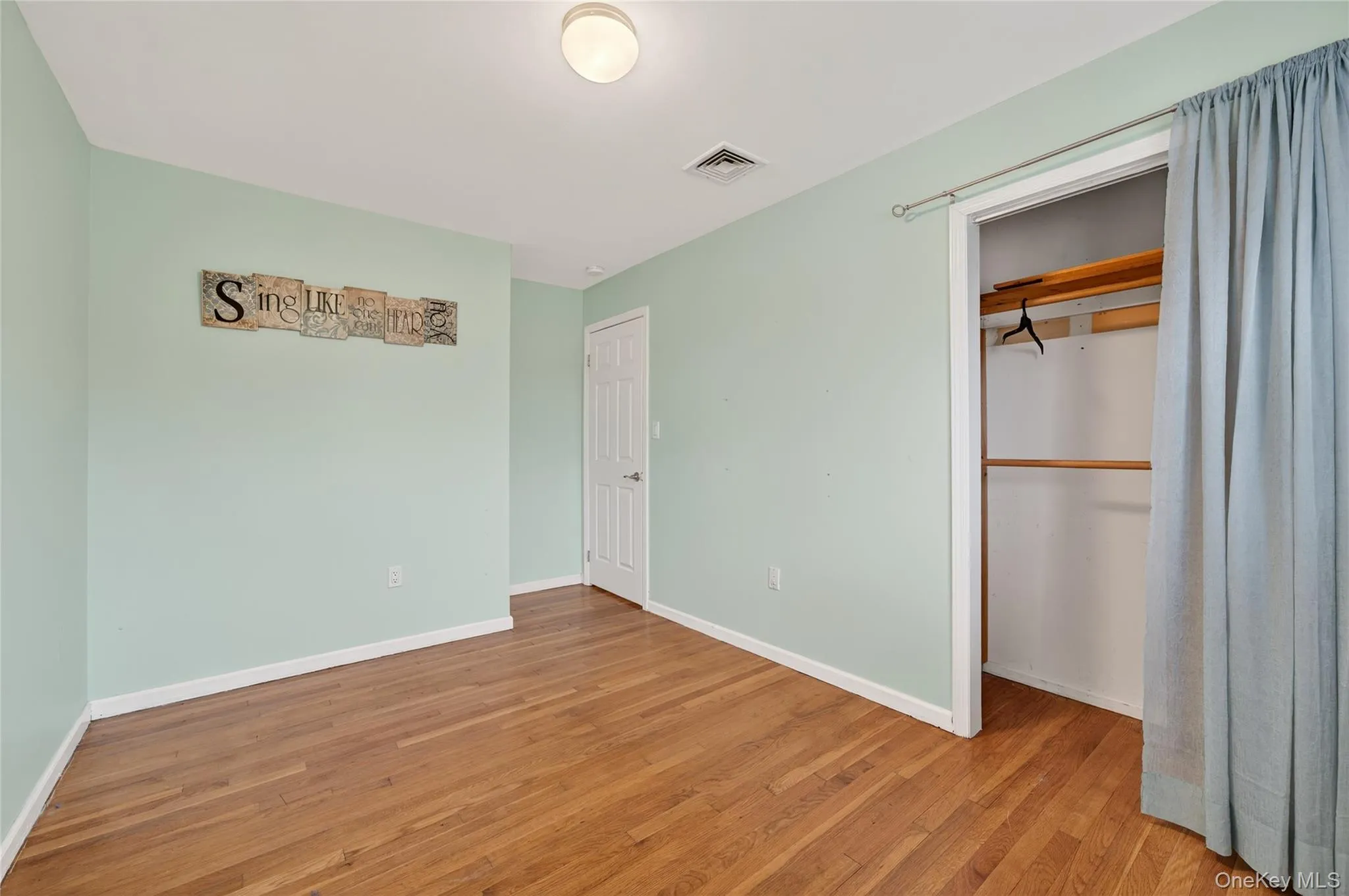 Unfurnished bedroom with wood finished floors and a closet Unfurnished bedroom with wood finished floors and a closet