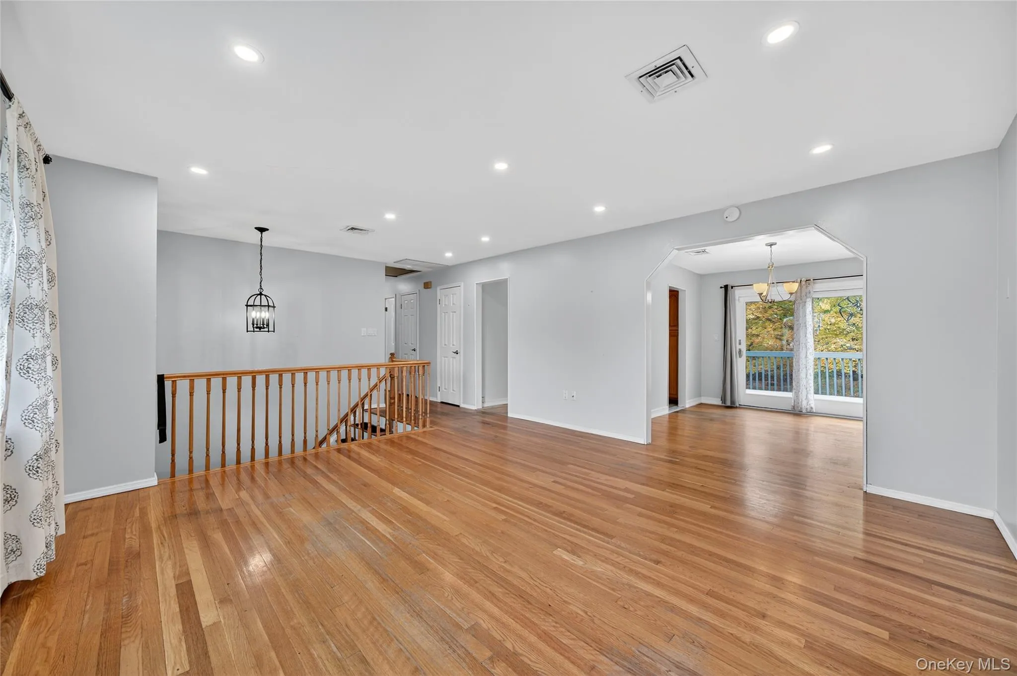 Spare room with a chandelier, light wood finished floors, recessed lighting, and arched walkways Spare room with a chandelier, light wood finished floors, recessed lighting, and arched walkways
