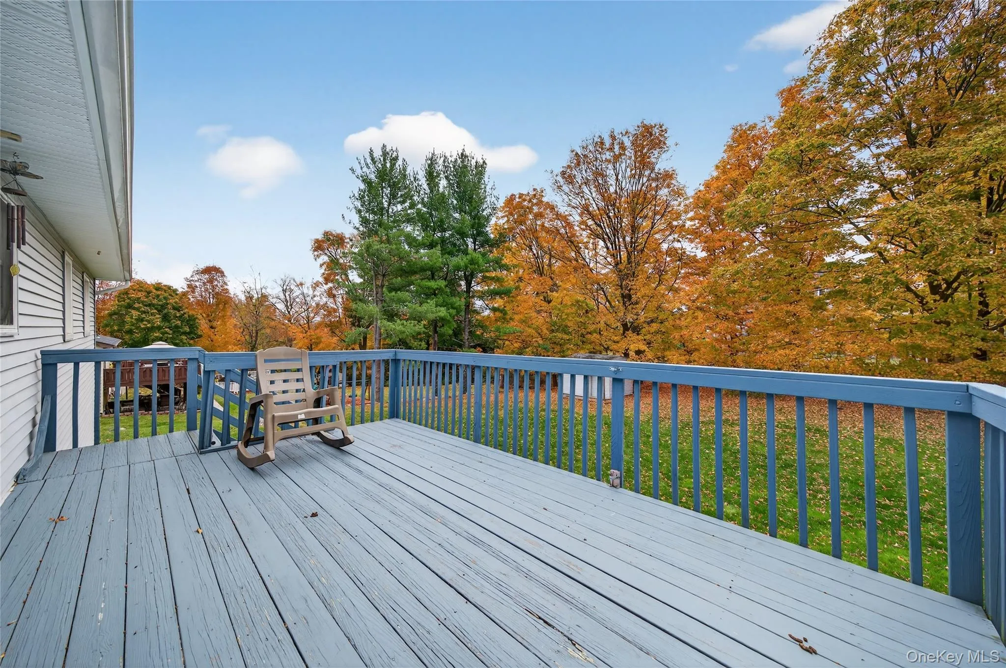Deck featuring a lawn and view of scattered trees Deck featuring a lawn and view of scattered trees