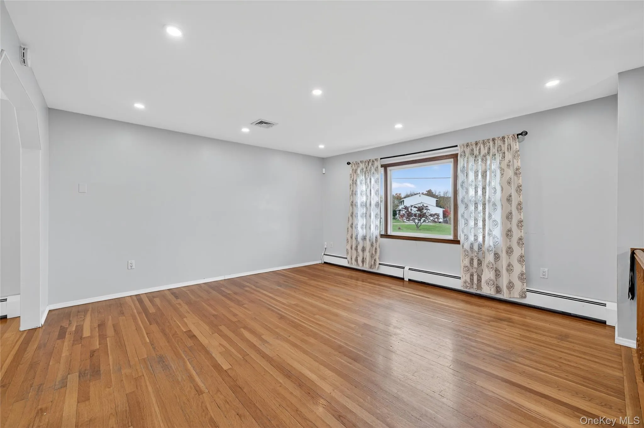 Empty room with recessed lighting, light wood-type flooring, and a baseboard radiator Empty room with recessed lighting, light wood-type flooring, and a baseboard radiator