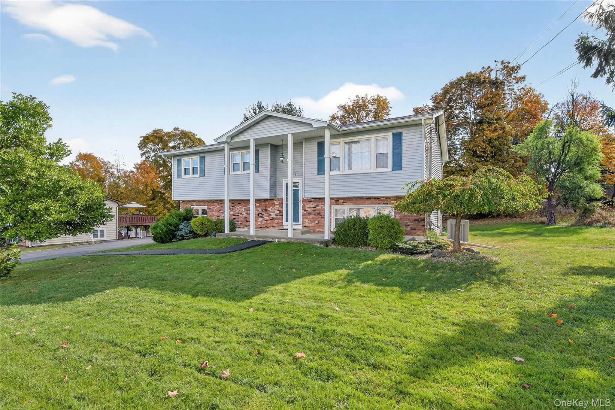 Bi-level home featuring brick siding and a front lawn Bi-level home featuring brick siding and a front lawn