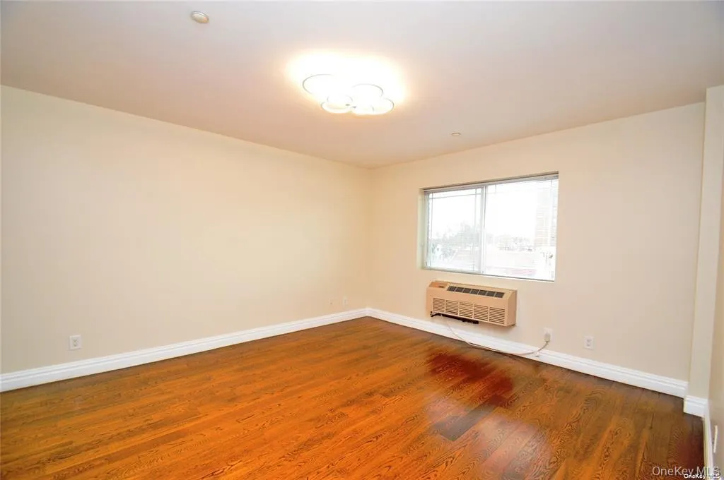 Unfurnished room with baseboards and wood finished floors Unfurnished room with baseboards and wood finished floors