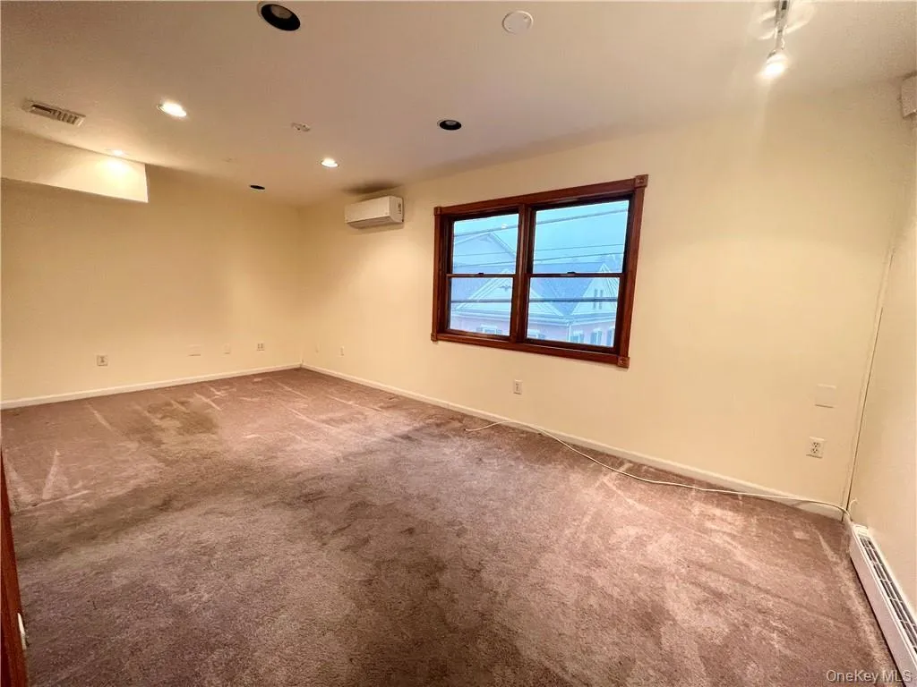 Empty room featuring a baseboard radiator, carpet flooring, and recessed lighting Empty room featuring a baseboard radiator, carpet flooring, and recessed lighting