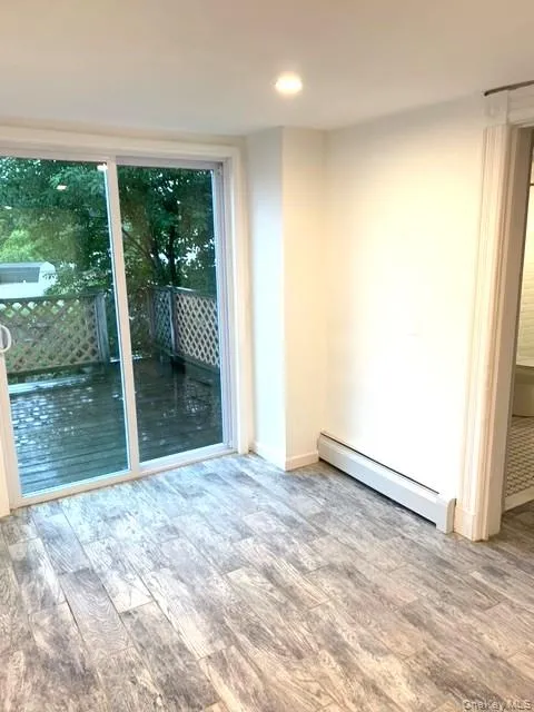 Spare room featuring a baseboard radiator, wood finished floors, and recessed lighting Spare room featuring a baseboard radiator, wood finished floors, and recessed lighting
