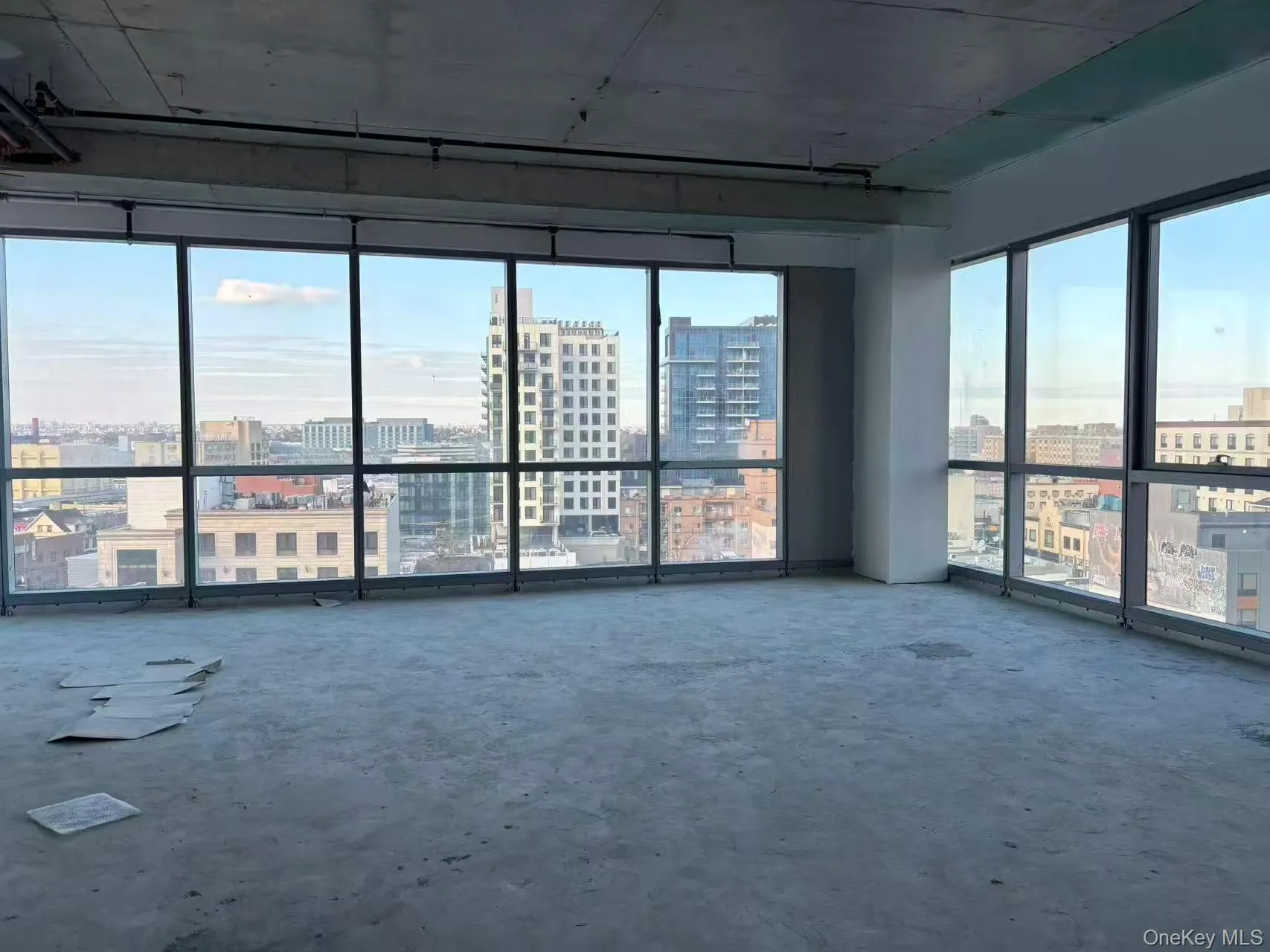 Unfurnished room with a city view and unfinished concrete floors Unfurnished room with a city view and unfinished concrete floors