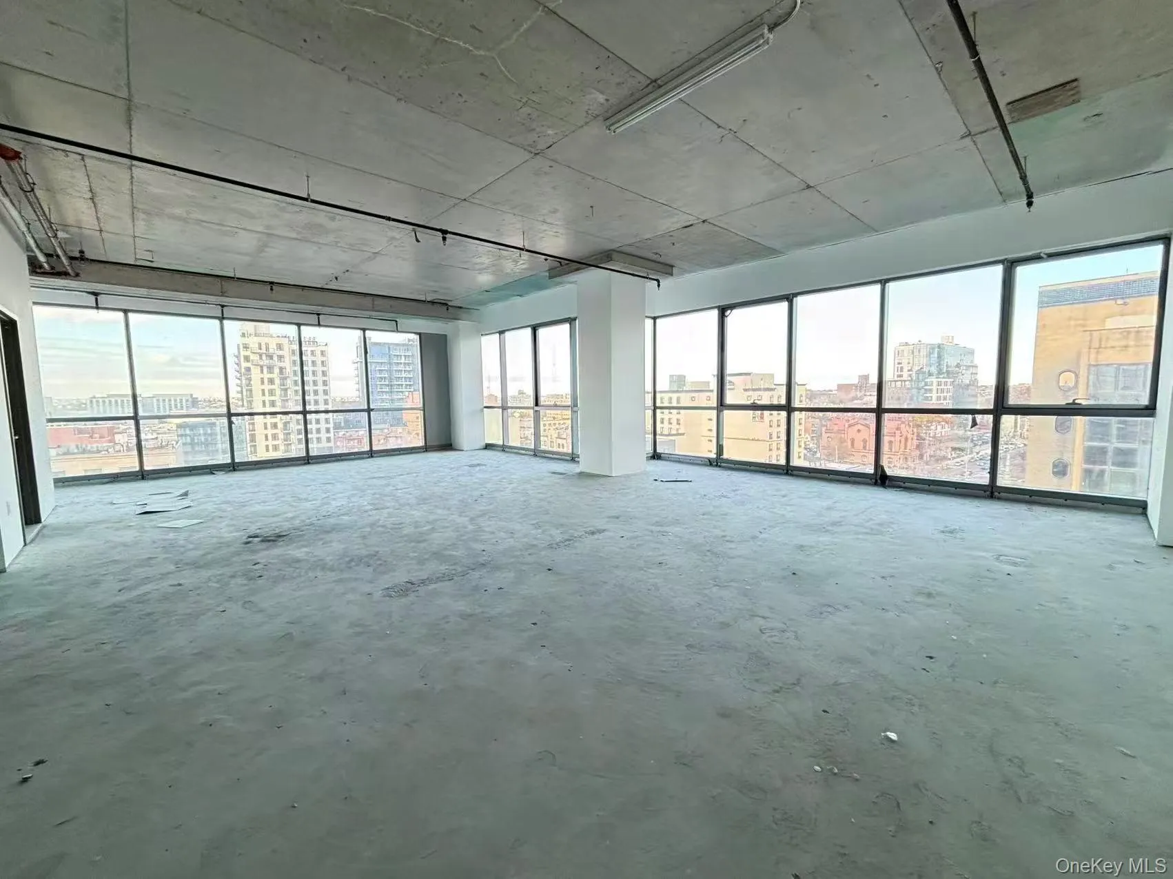 Empty room with a view of city and unfinished concrete floors Empty room with a view of city and unfinished concrete floors