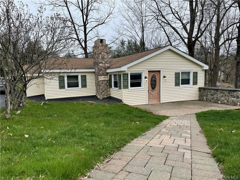 View of front of property featuring a front yard, a patio area, a chimney, and a shingled roof View of front of property featuring a front yard, a patio area, a chimney, and a shingled roof
