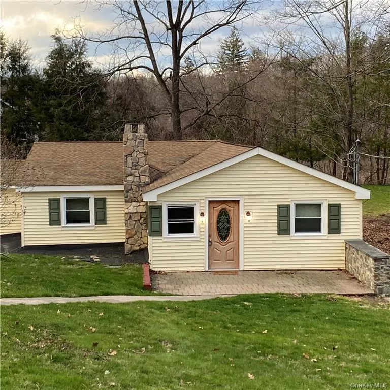 View of front of house featuring a front yard, a chimney, a shingled roof, and a patio area View of front of house featuring a front yard, a chimney, a shingled roof, and a patio area