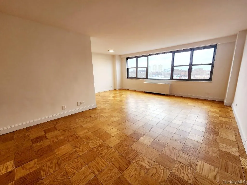 Empty room featuring a city view and baseboards Empty room featuring a city view and baseboards