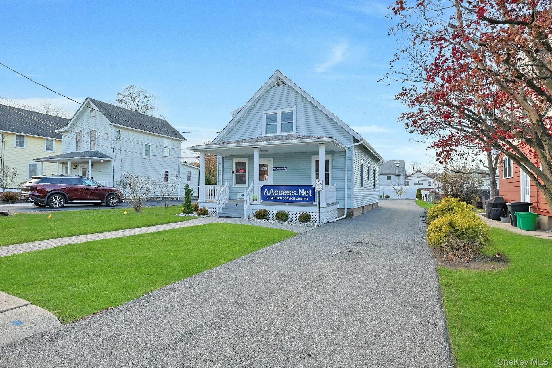 View of front facade featuring a front yard, a porch, and driveway View of front facade featuring a front yard, a porch, and driveway