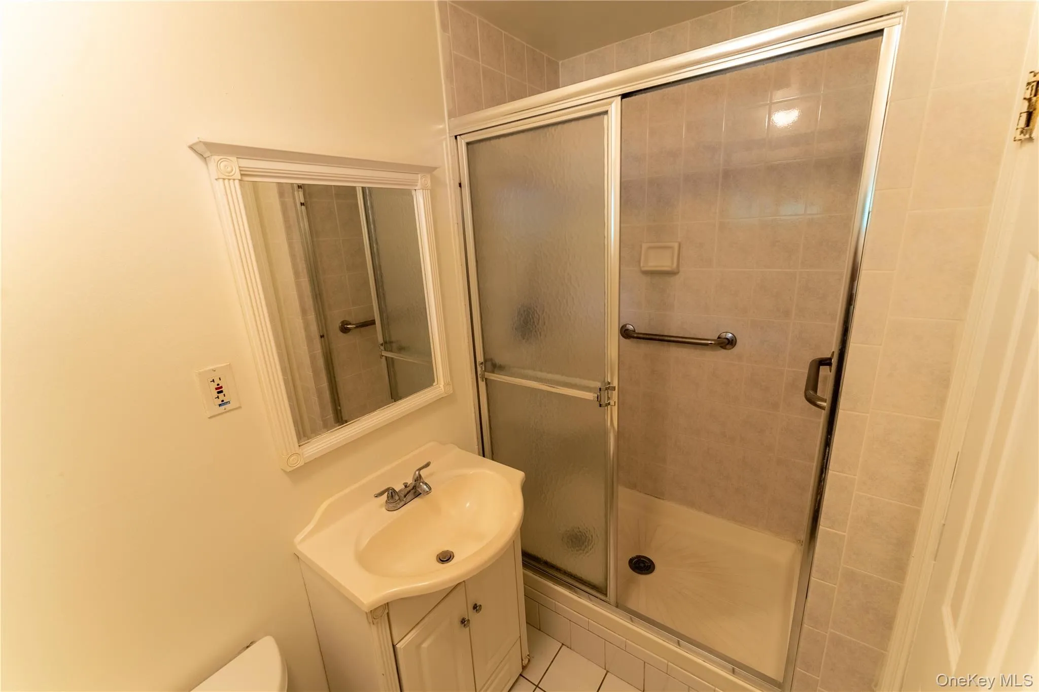 Full bath featuring vanity, light tile patterned flooring, and a stall shower Full bath featuring vanity, light tile patterned flooring, and a stall shower