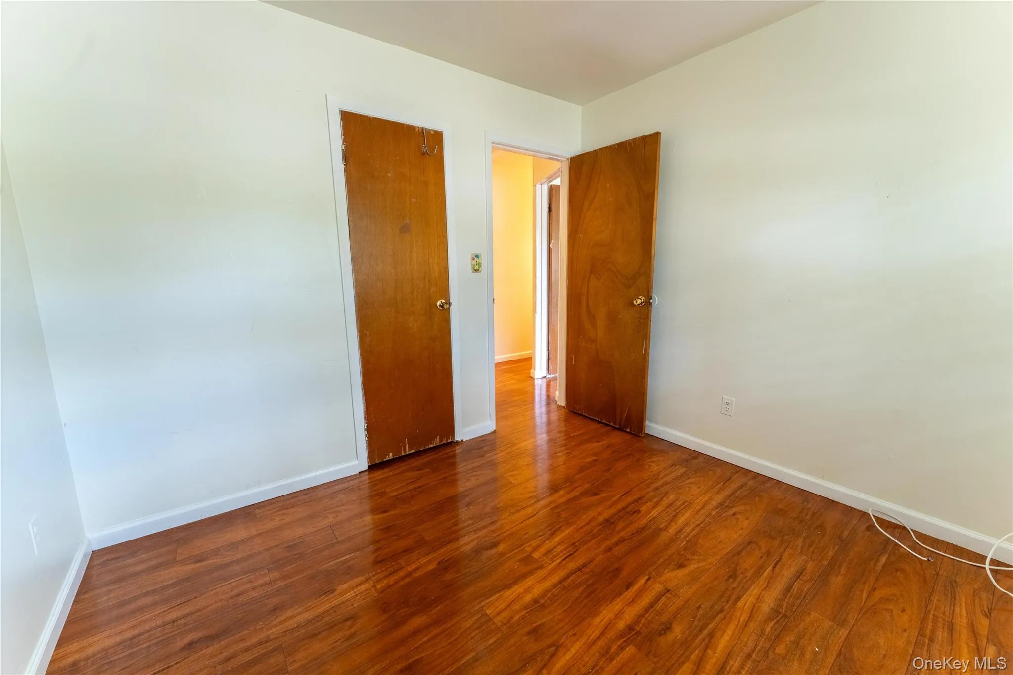 Unfurnished room featuring baseboards and wood finished floors Unfurnished room featuring baseboards and wood finished floors