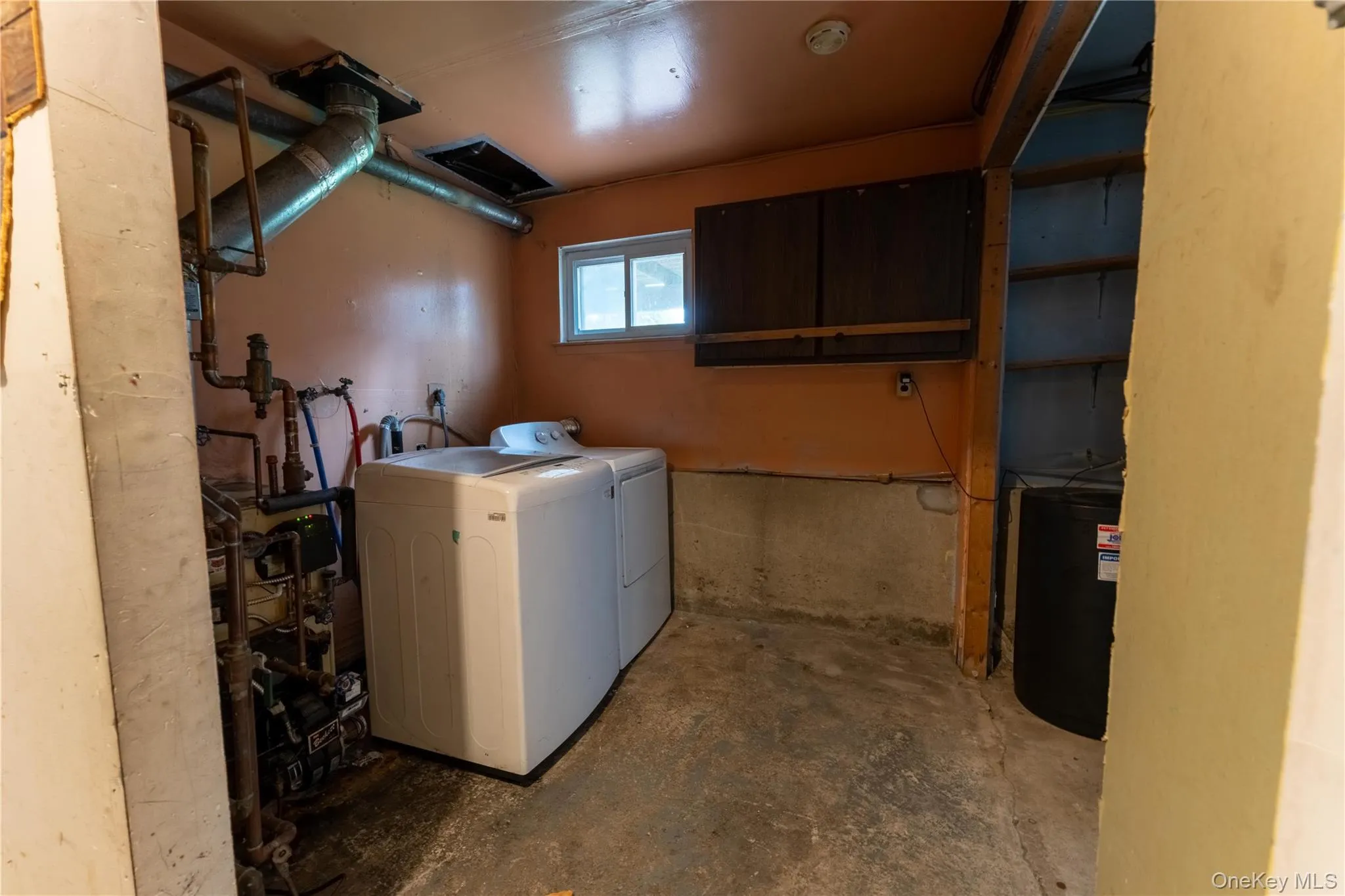 Laundry room featuring concrete flooring and washer and dryer Laundry room featuring concrete flooring and washer and dryer