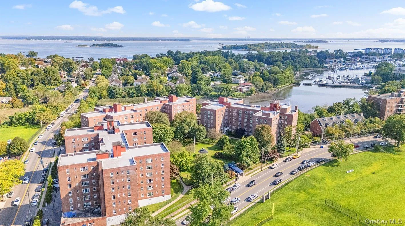 Drone / aerial view of a large body of water and apartment complex / building Drone / aerial view of a large body of water and apartment complex / building
