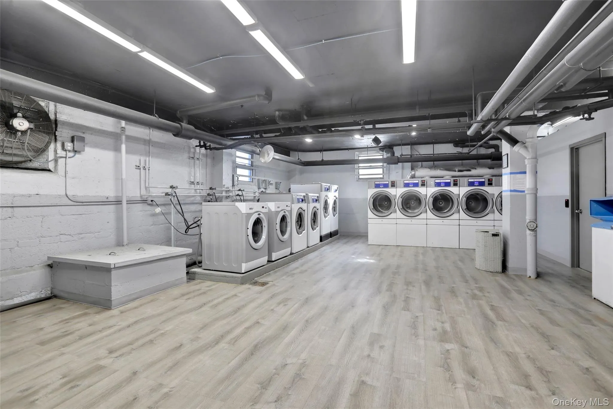 Community laundry with independent washer and dryer and light wood finished floors Community laundry with independent washer and dryer and light wood finished floors