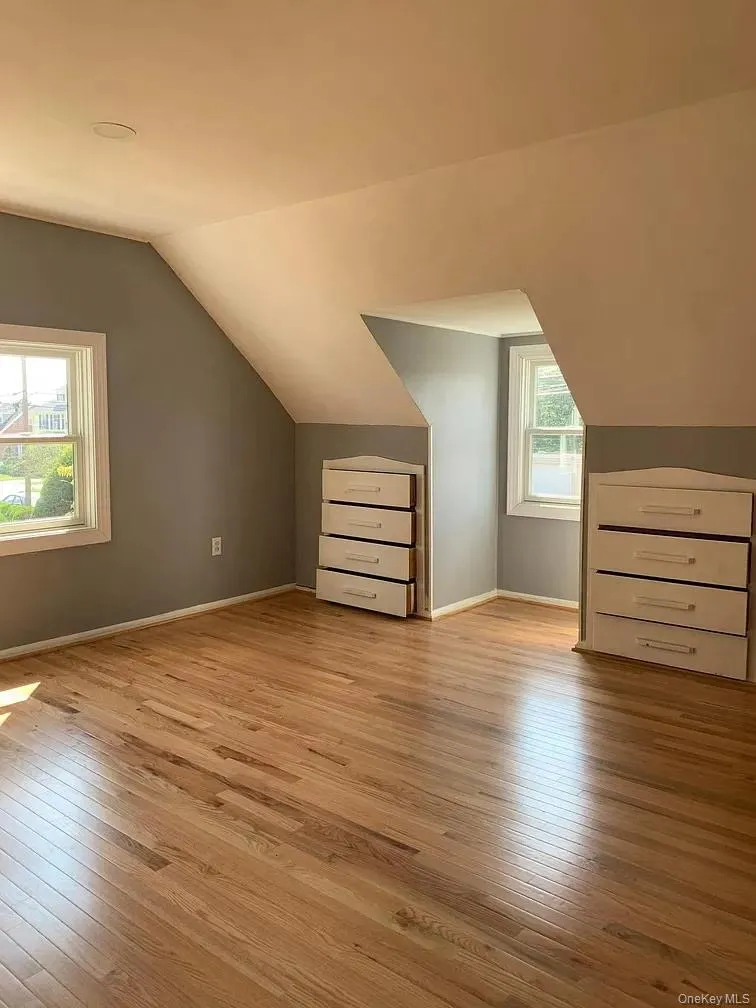 Bonus room with vaulted ceiling and light wood finished floors Bonus room with vaulted ceiling and light wood finished floors