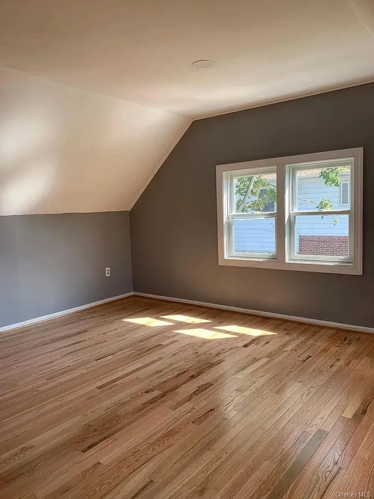 Bonus room featuring light wood finished floors and lofted ceiling Bonus room featuring light wood finished floors and lofted ceiling