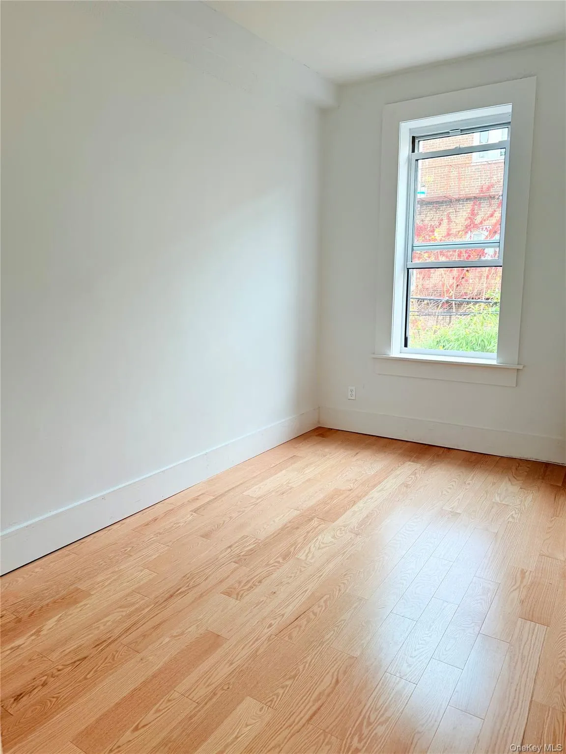 Unfurnished room with light wood finished floors and baseboards Unfurnished room with light wood finished floors and baseboards