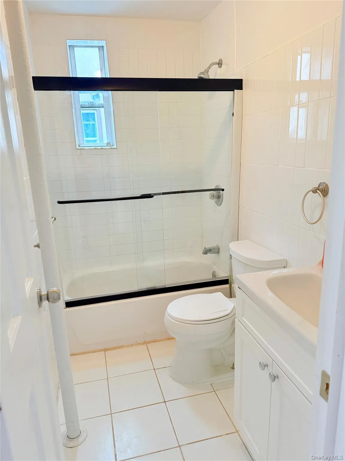 Bathroom with light tile patterned flooring, combined bath / shower with glass door, and vanity Bathroom with light tile patterned flooring, combined bath / shower with glass door, and vanity