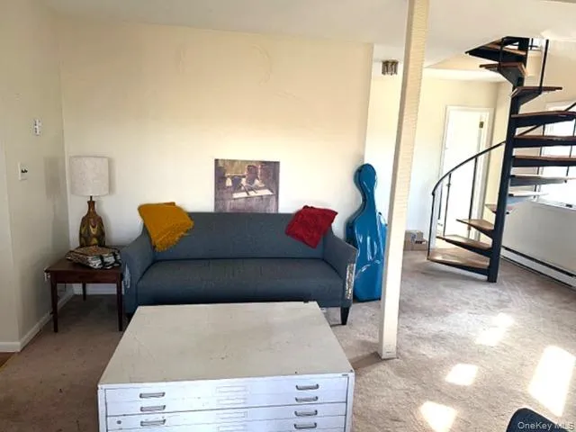 Carpeted living area featuring stairway Carpeted living area featuring stairway