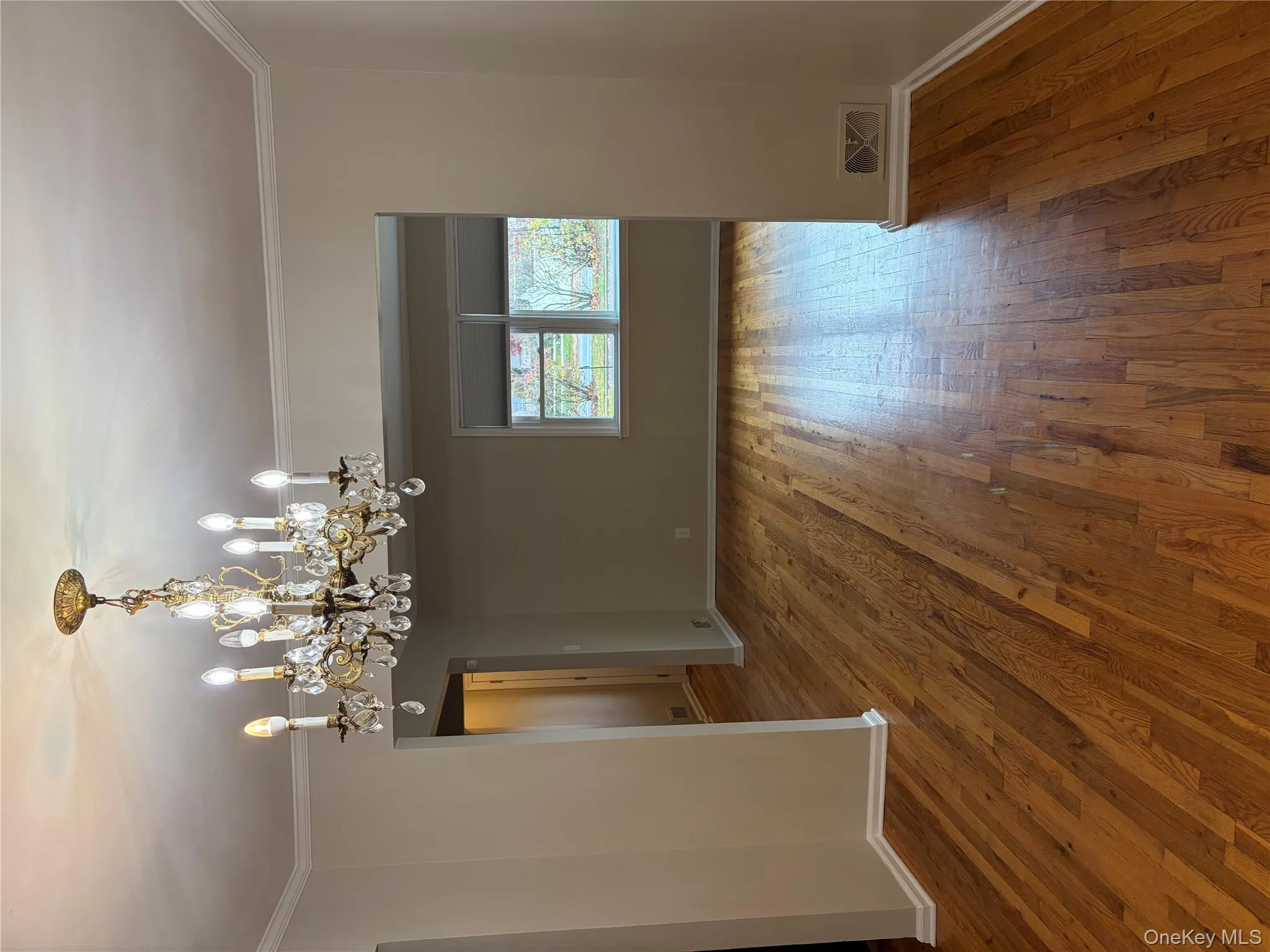 Unfurnished room featuring ornamental molding, dark wood-style floors, and a chandelier Unfurnished room featuring ornamental molding, dark wood-style floors, and a chandelier