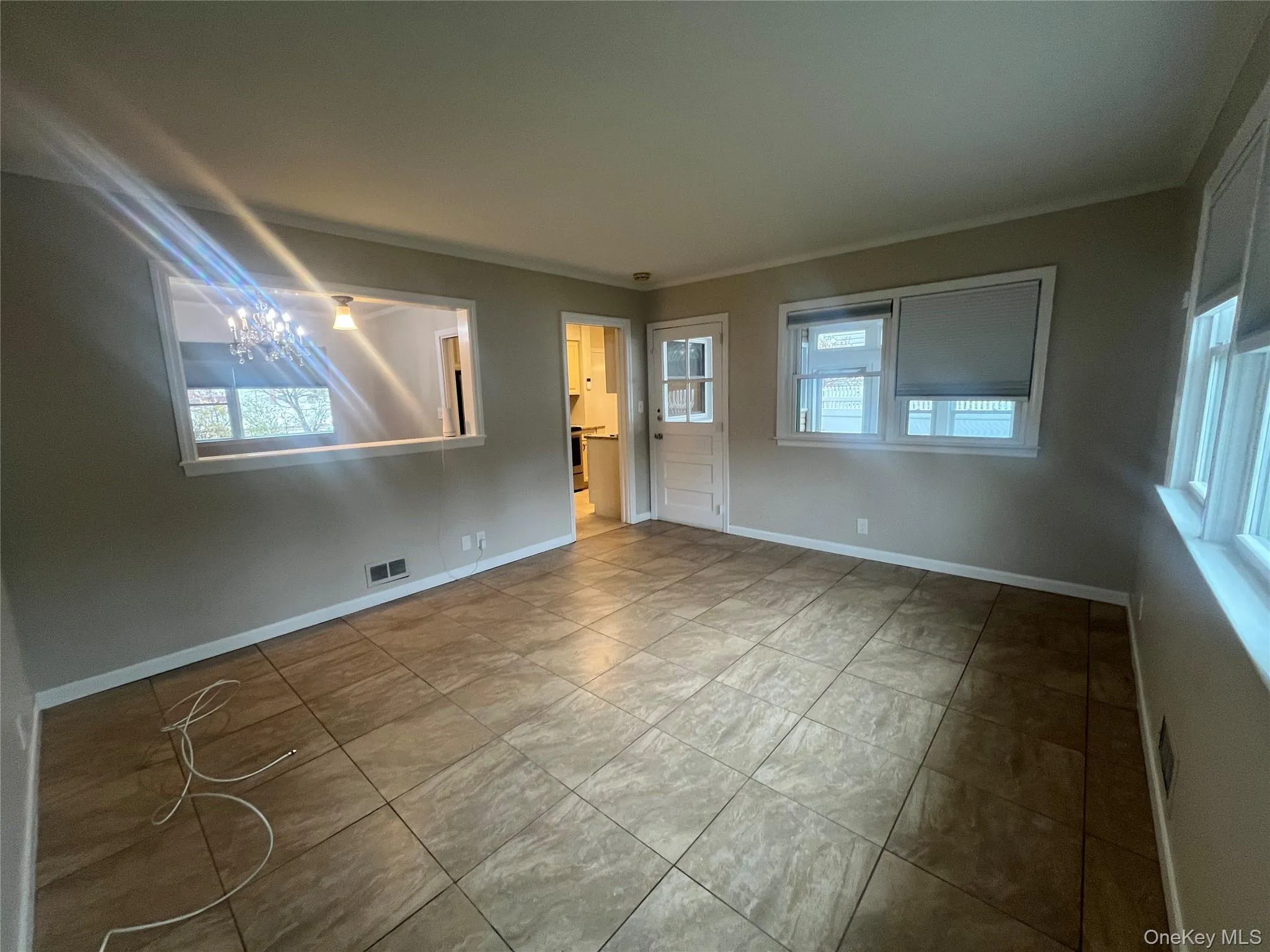 Unfurnished den/family room featuring baseboards and crown molding Unfurnished den/family room featuring baseboards and crown molding