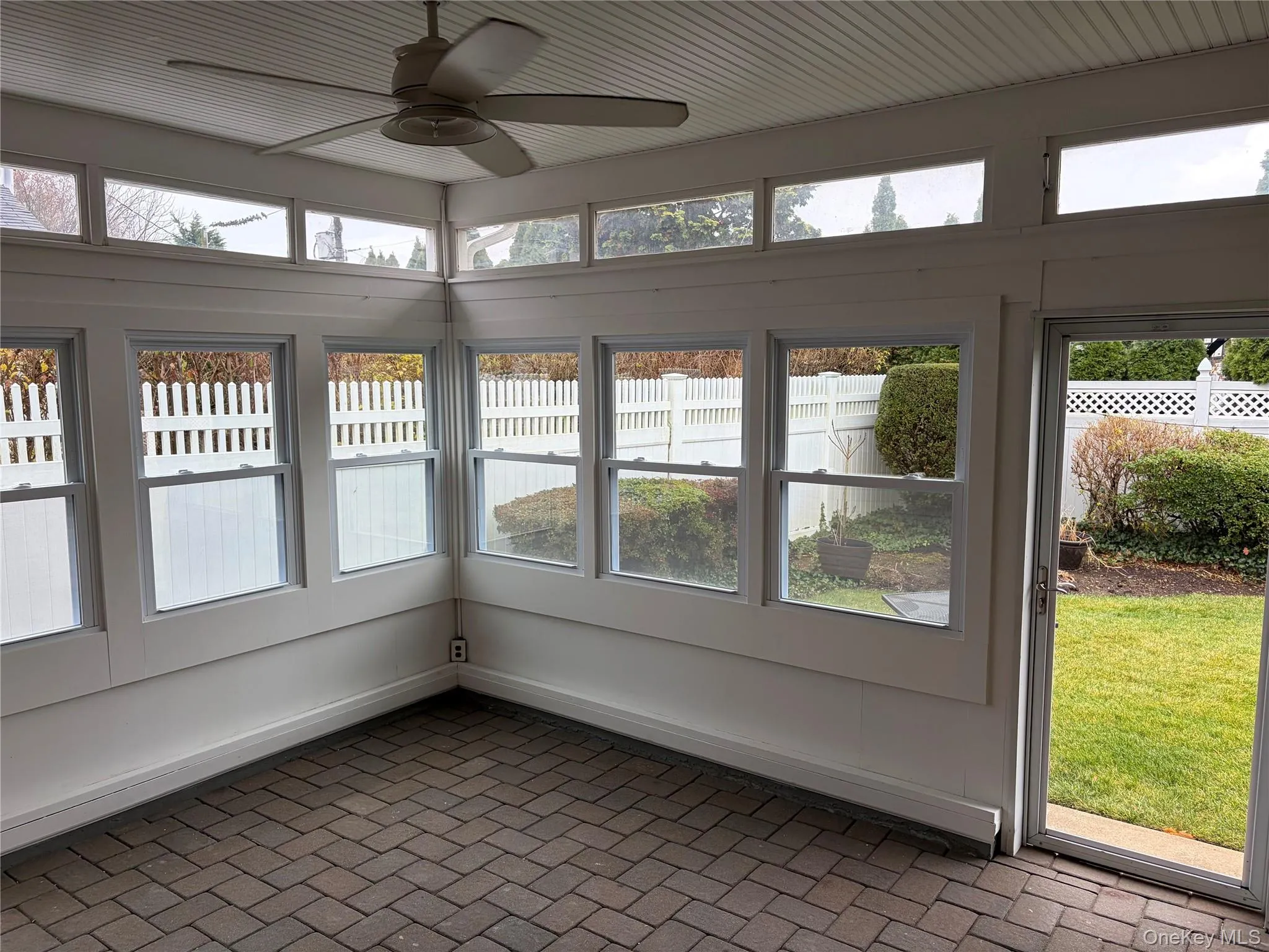 Unfurnished sunroom featuring brick patterned flooring and healthy amount of natural light Unfurnished sunroom featuring brick patterned flooring and healthy amount of natural light