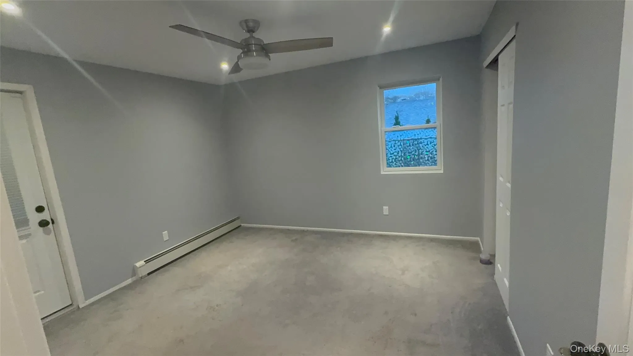 Unfurnished room featuring baseboard heating, ceiling fan, and light carpet Unfurnished room featuring baseboard heating, ceiling fan, and light carpet