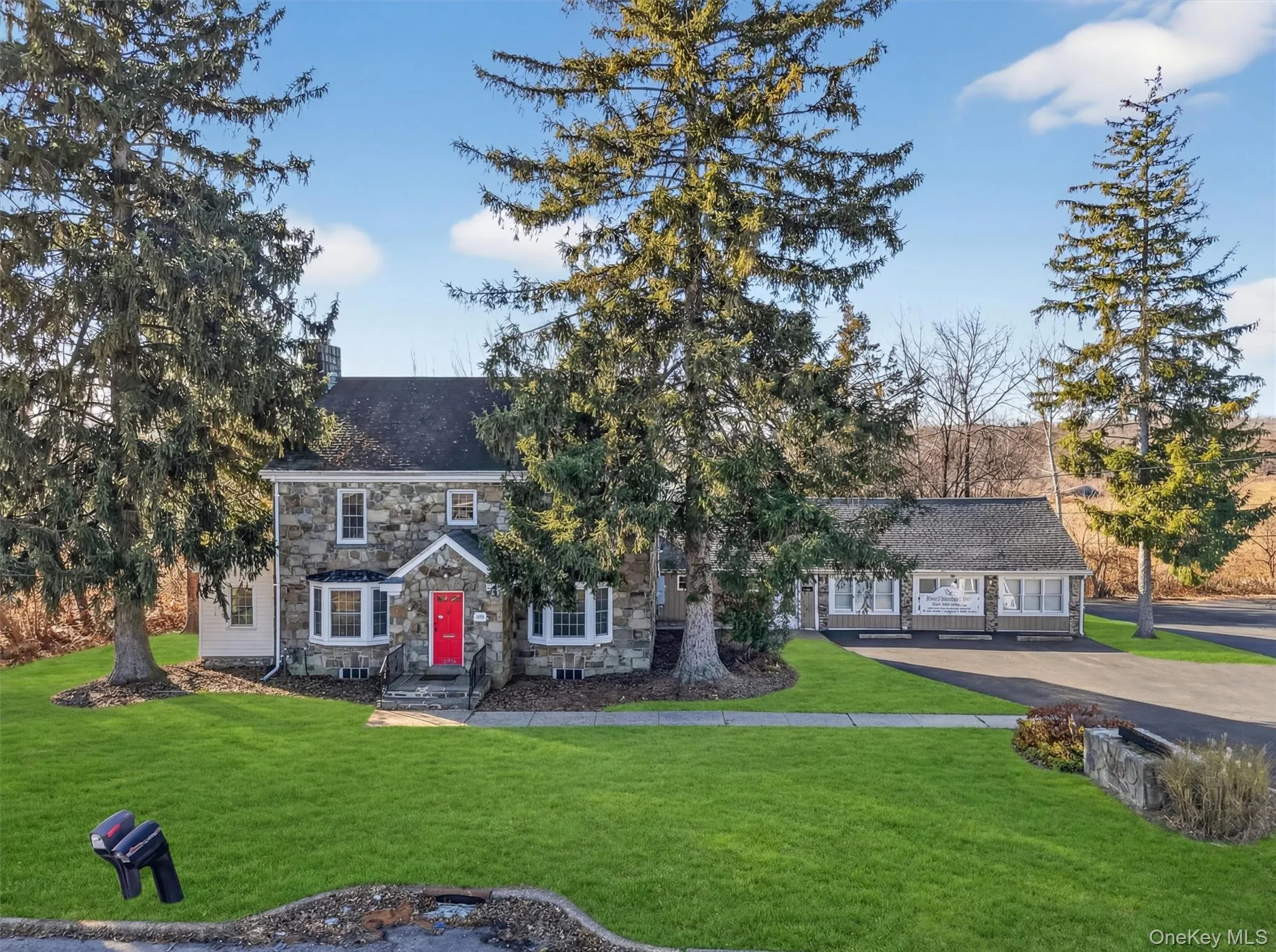 View of front of home featuring stone siding, a front yard, and a chimney View of front of home featuring stone siding, a front yard, and a chimney