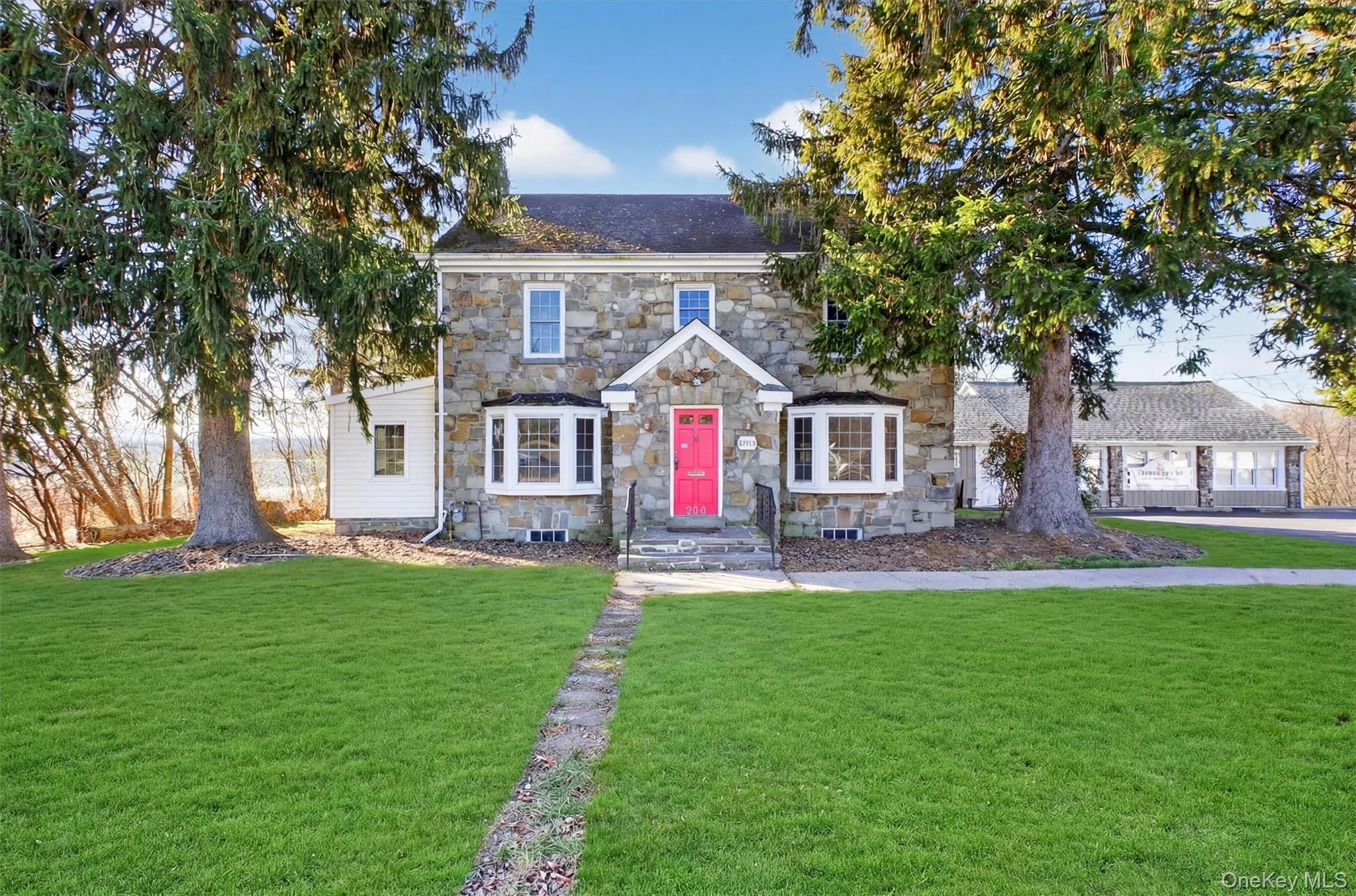 View of front of home featuring a front yard and stone siding View of front of home featuring a front yard and stone siding