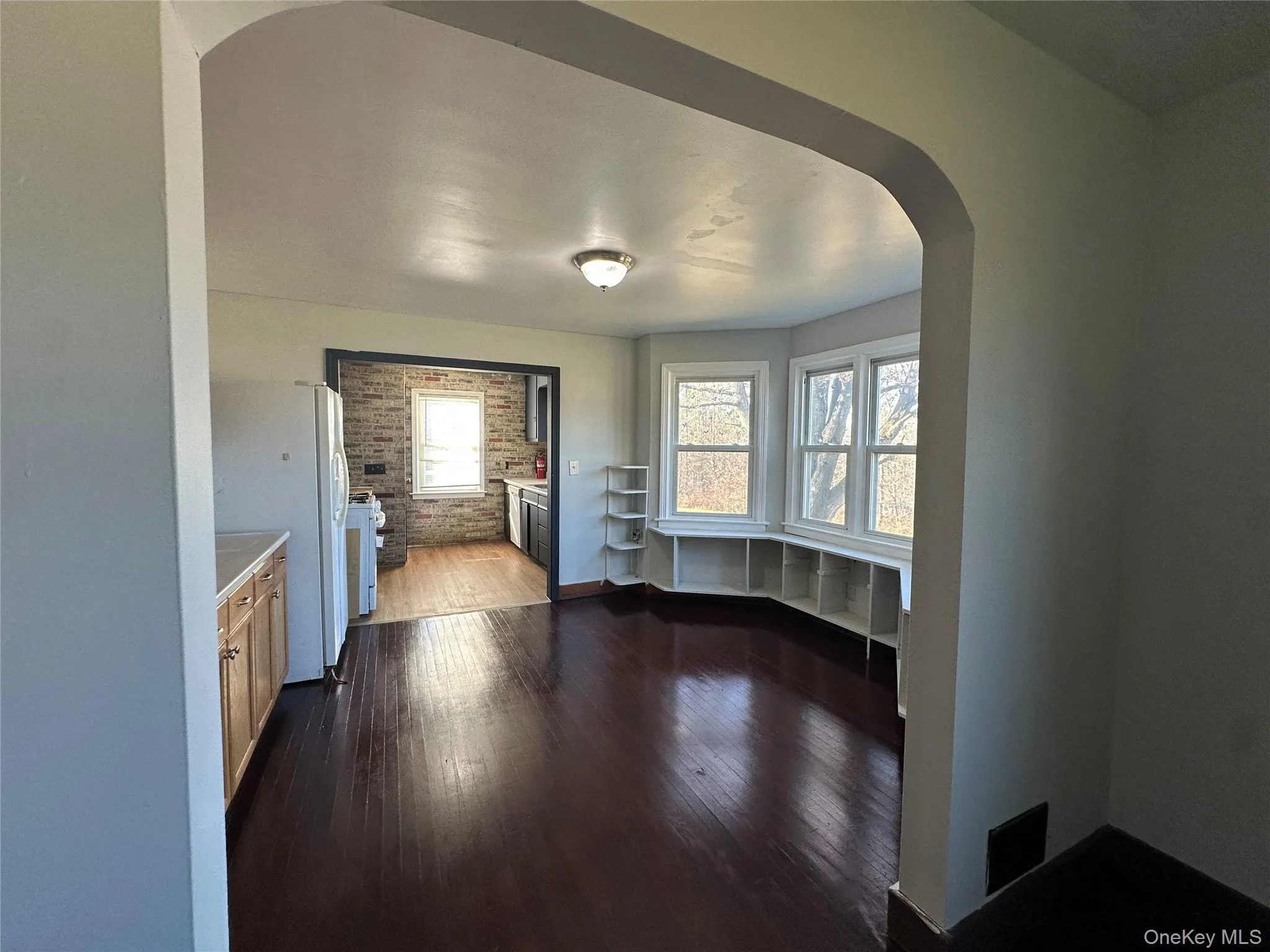 Unfurnished dining area with arched walkways and dark wood-style floors Unfurnished dining area with arched walkways and dark wood-style floors