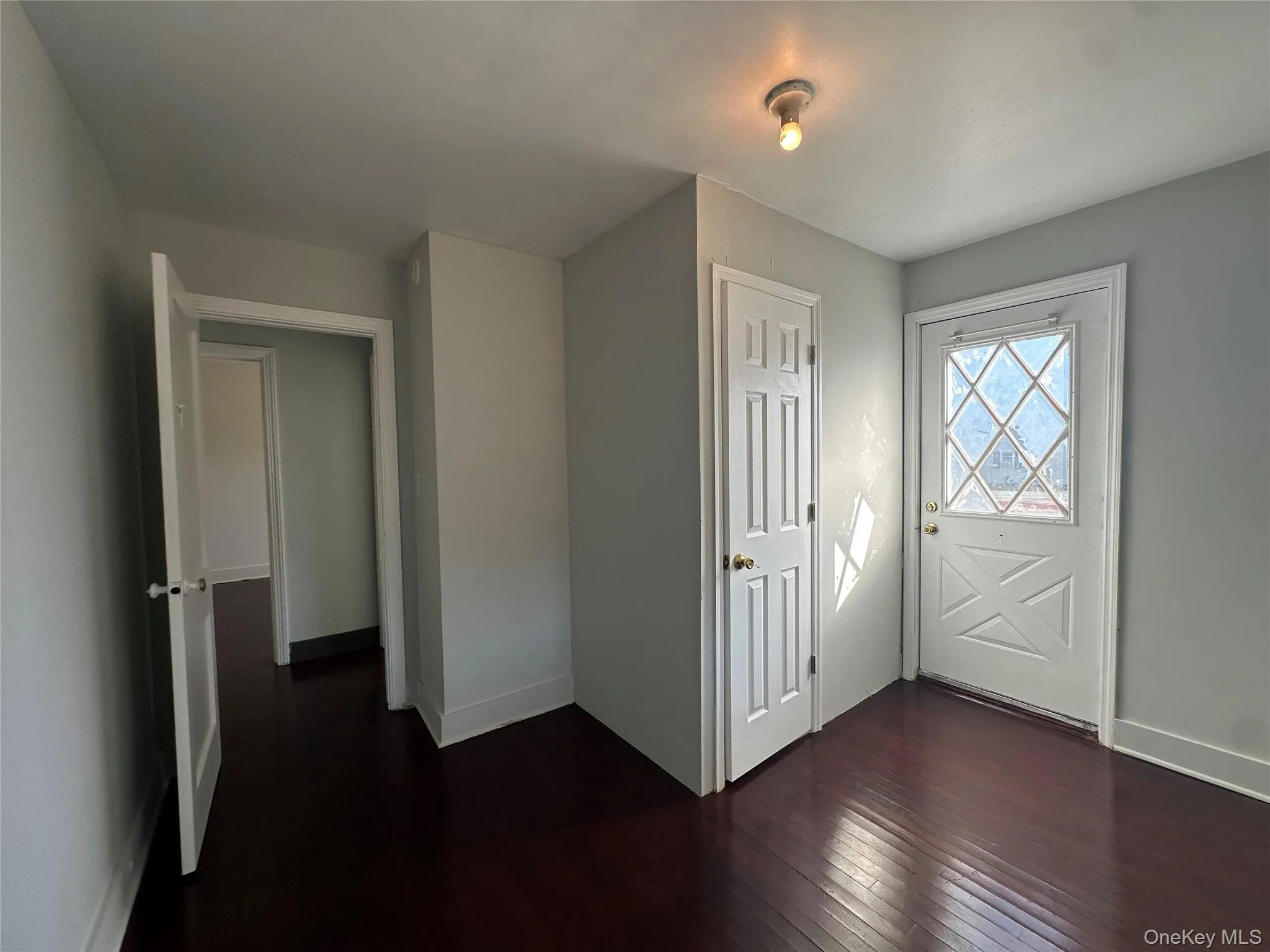 Entryway featuring dark wood-type flooring and baseboards Entryway featuring dark wood-type flooring and baseboards