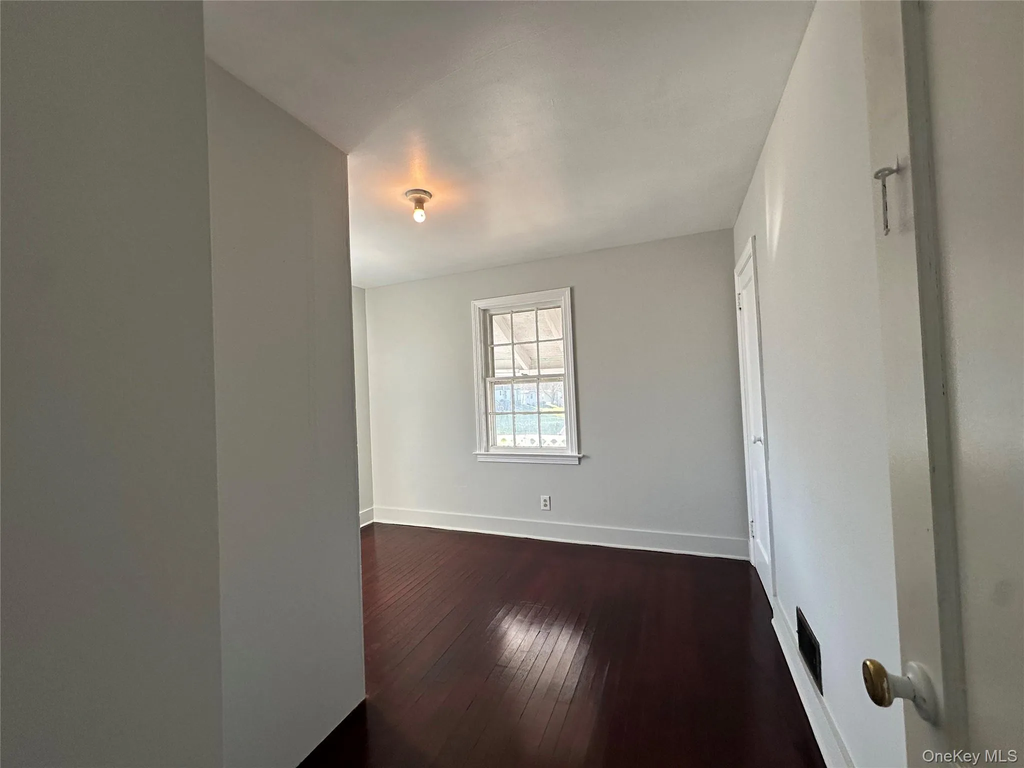 Spare room with baseboards and dark wood finished floors Spare room with baseboards and dark wood finished floors