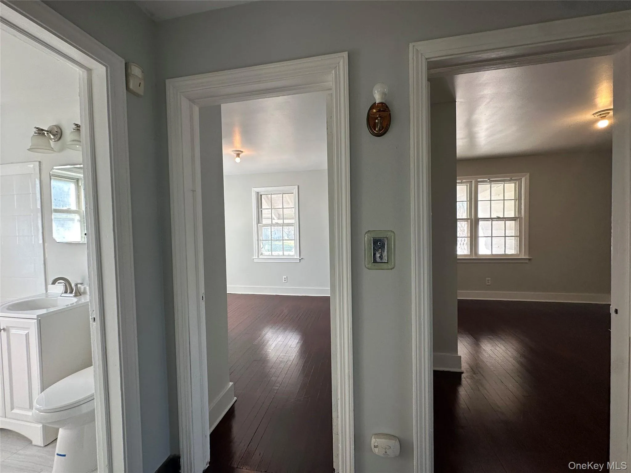 Hall with dark wood-style flooring and healthy amount of natural light Hall with dark wood-style flooring and healthy amount of natural light