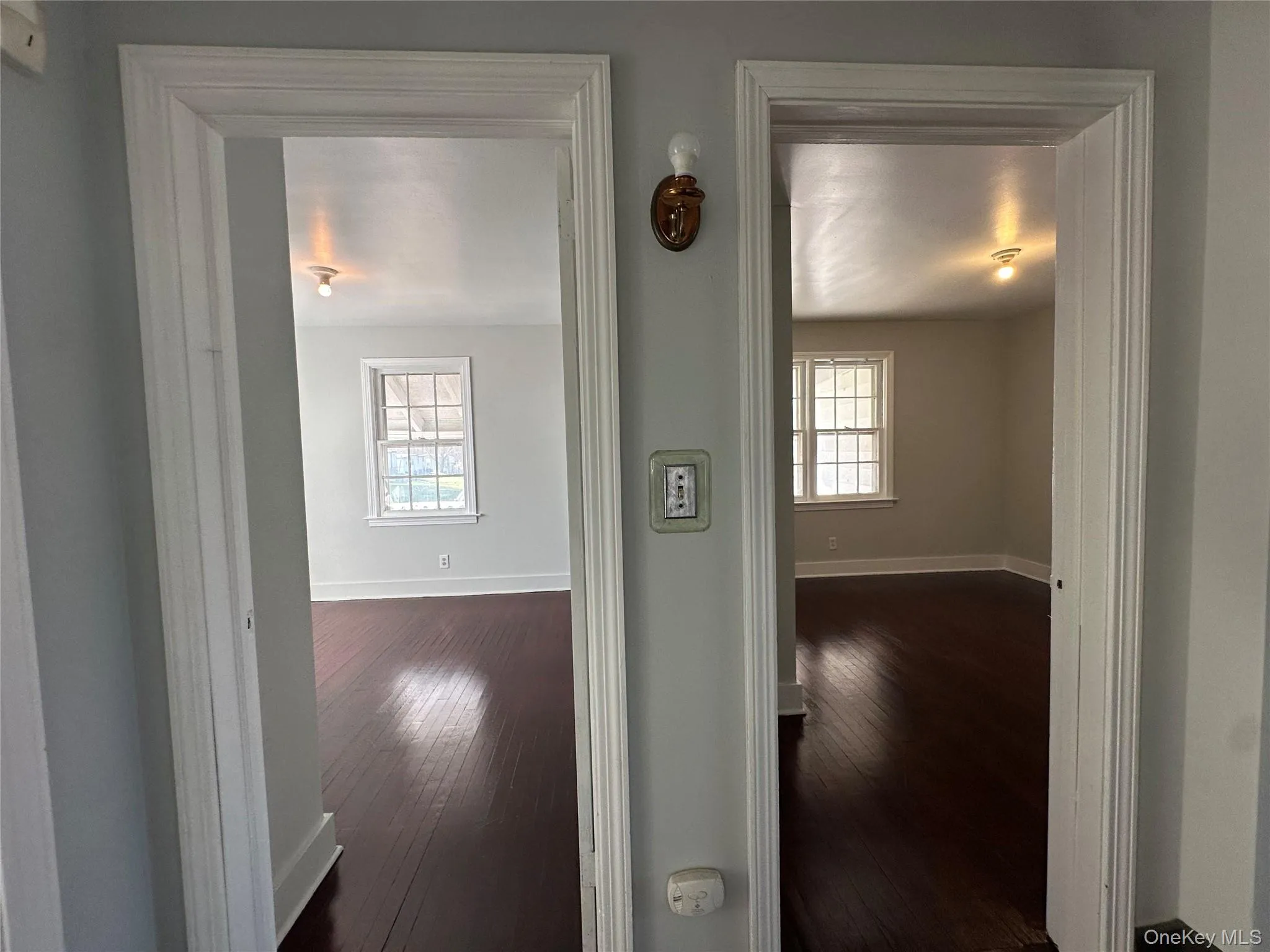 Corridor with dark wood-style flooring and baseboards Corridor with dark wood-style flooring and baseboards