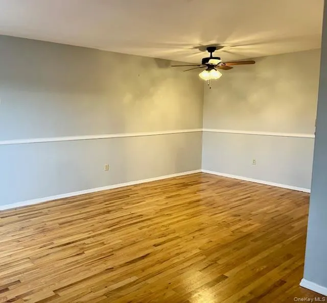 Unfurnished room featuring wood finished floors and a ceiling fan Unfurnished room featuring wood finished floors and a ceiling fan