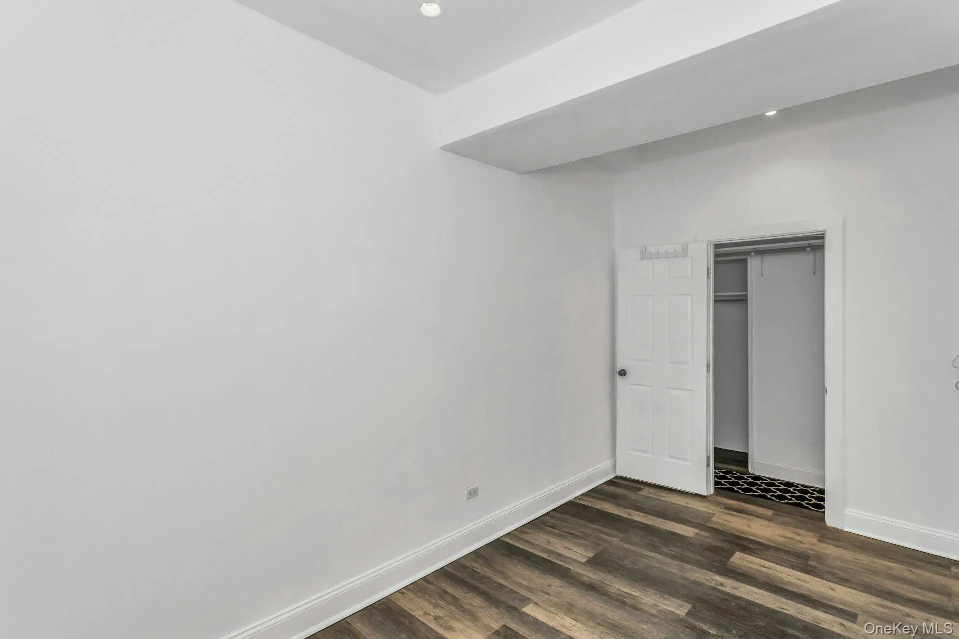 Unfurnished bedroom featuring dark wood-style flooring, a closet, and recessed lighting Unfurnished bedroom featuring dark wood-style flooring, a closet, and recessed lighting