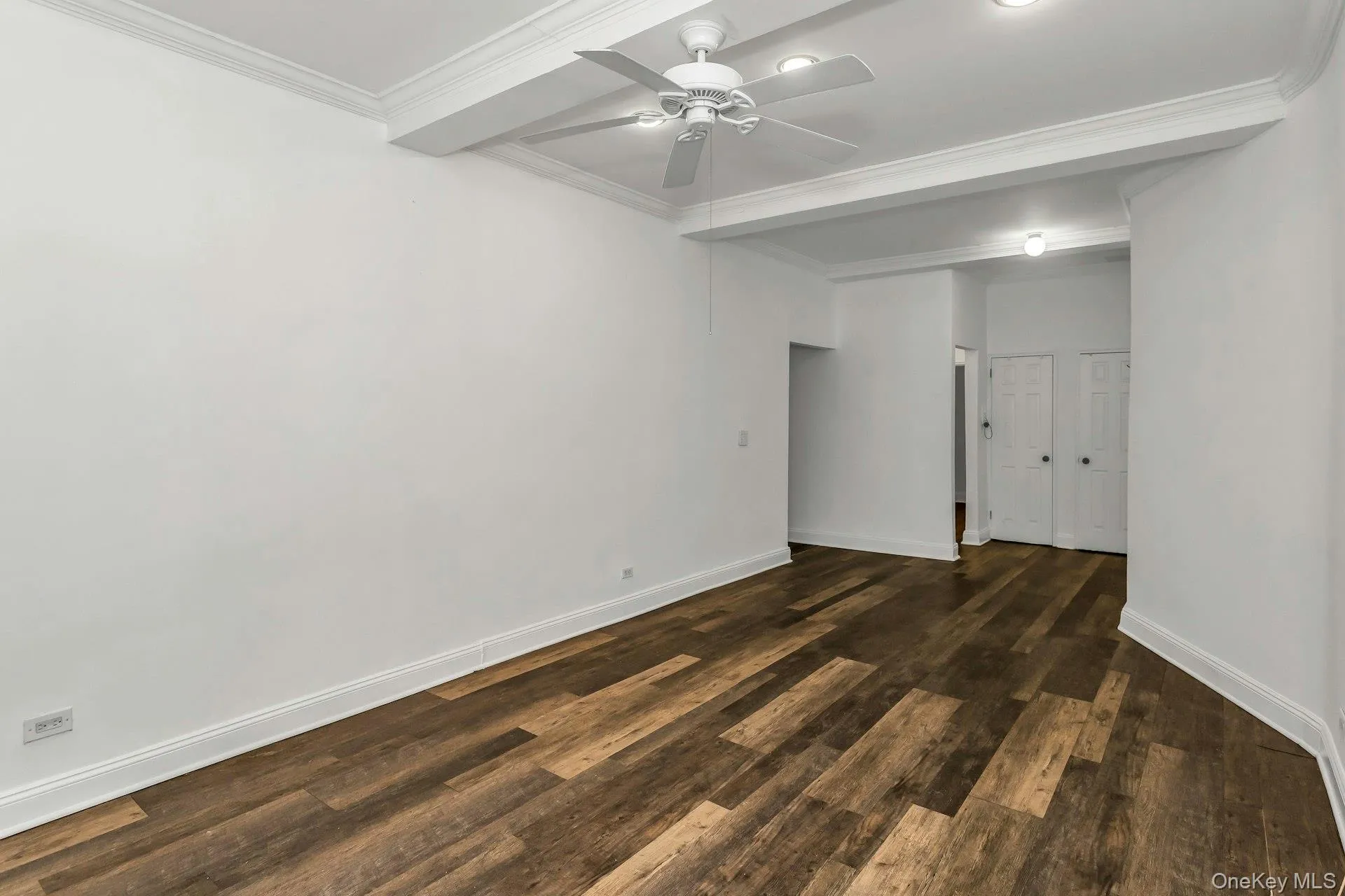 Unfurnished room with dark wood finished floors, crown molding, and ceiling fan Unfurnished room with dark wood finished floors, crown molding, and ceiling fan