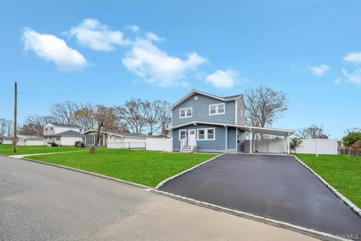 View of front of property with a carport and asphalt driveway