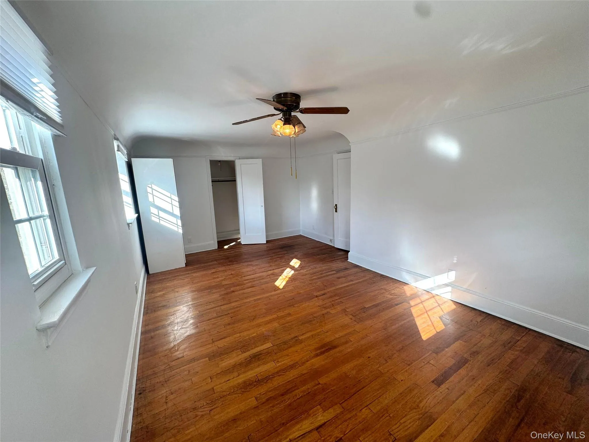 Unfurnished bedroom featuring a ceiling fan and hardwood / wood-style flooring Unfurnished bedroom featuring a ceiling fan and hardwood / wood-style flooring