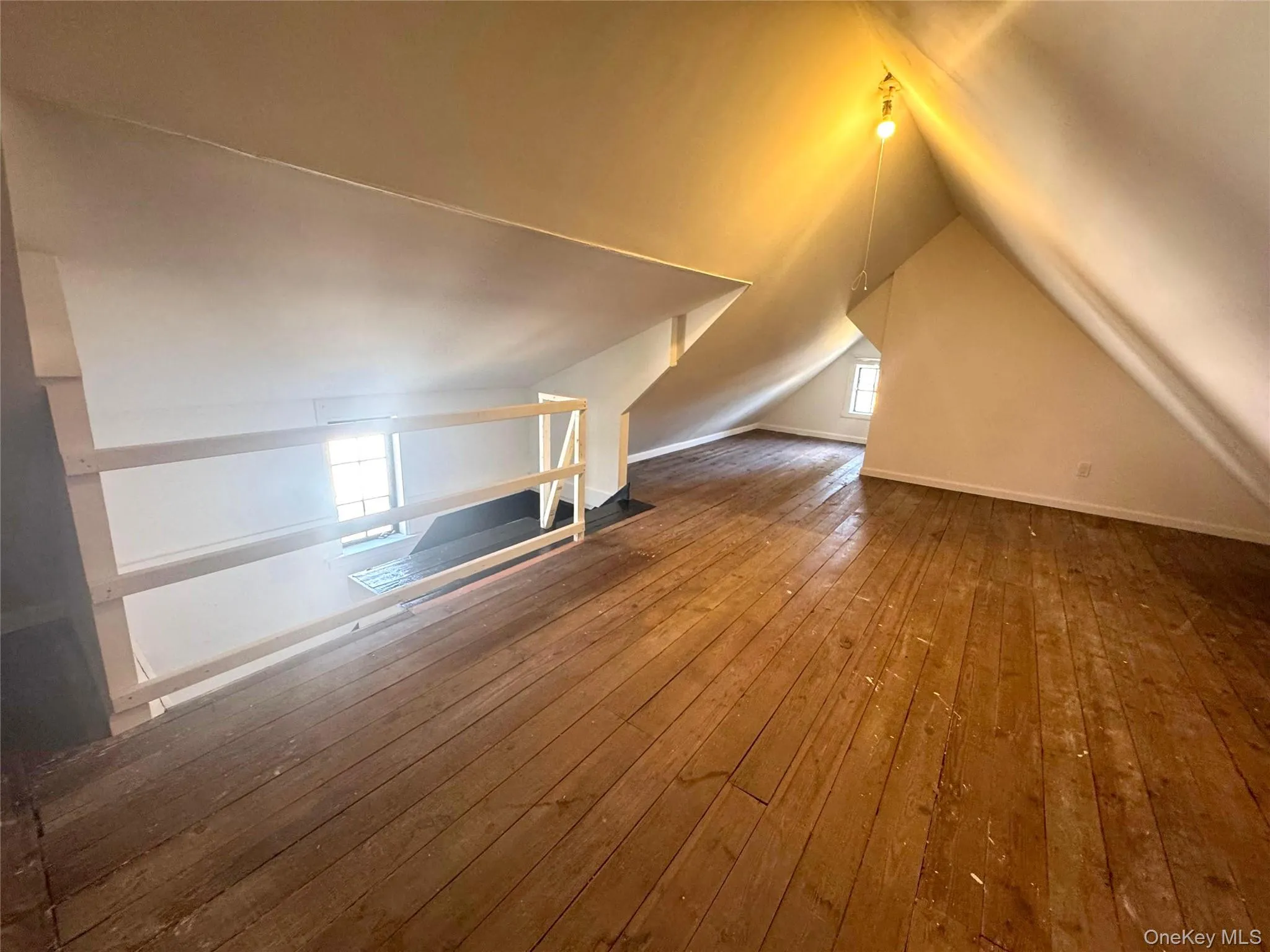 Additional living space featuring plenty of natural light, vaulted ceiling, and hardwood / wood-style flooring Additional living space featuring plenty of natural light, vaulted ceiling, and hardwood / wood-style flooring
