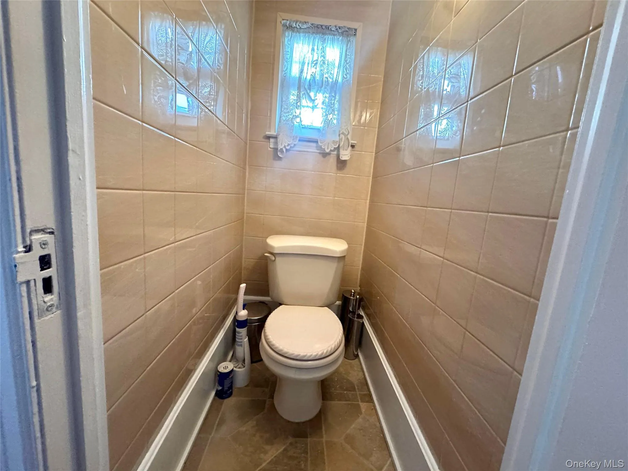 Bathroom featuring tile walls and tile patterned floors Bathroom featuring tile walls and tile patterned floors