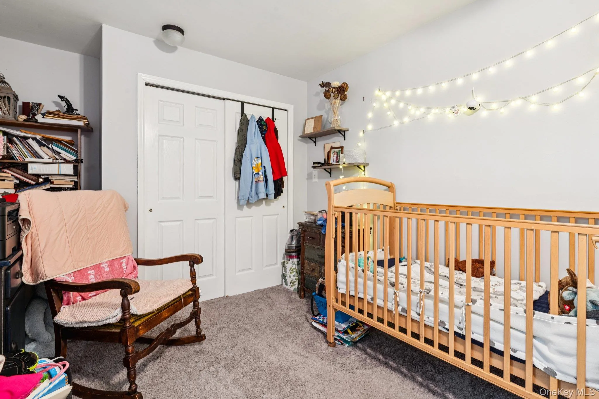 Carpeted bedroom featuring a nursery area and a closet Carpeted bedroom featuring a nursery area and a closet