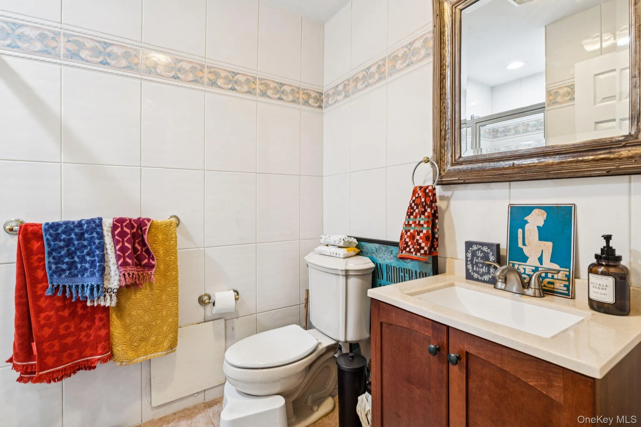 Full bathroom with vanity, an enclosed shower, tile walls, and tile patterned flooring Full bathroom with vanity, an enclosed shower, tile walls, and tile patterned flooring