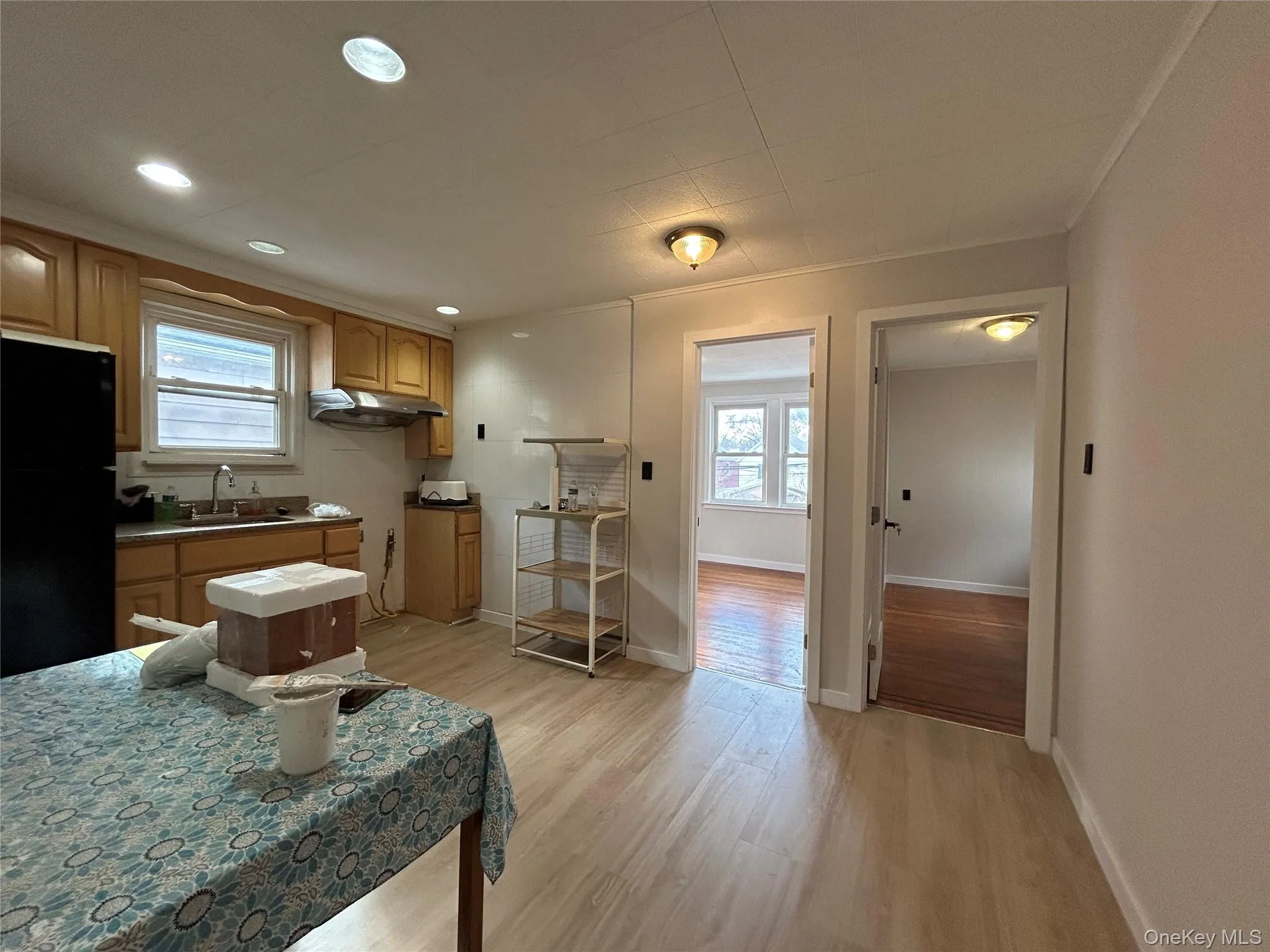 Kitchen featuring freestanding refrigerator, light wood finished floors, recessed lighting, plenty of natural light, and ornamental molding Kitchen featuring freestanding refrigerator, light wood finished floors, recessed lighting, plenty of natural light, and ornamental molding