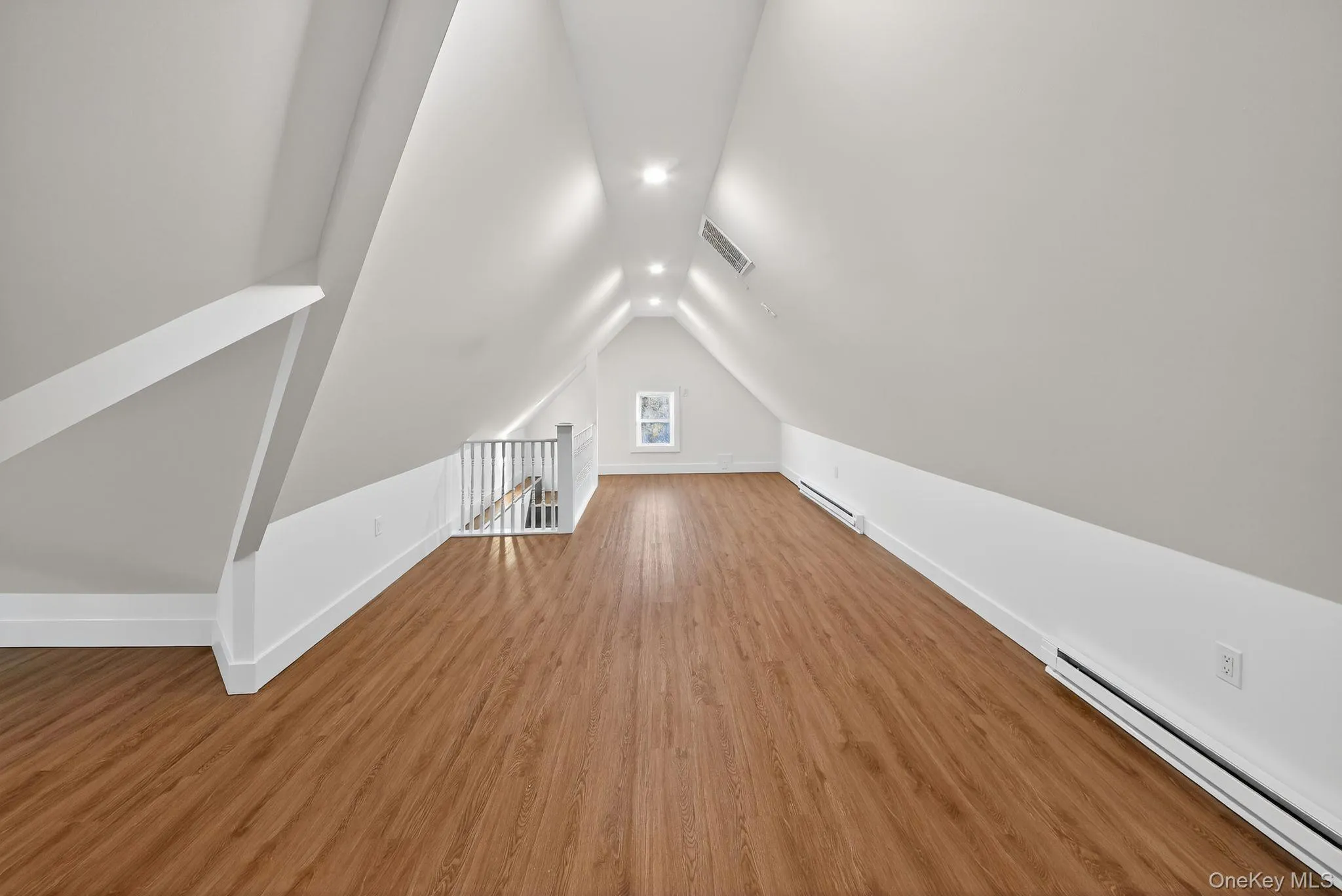 Additional living space with a baseboard heating unit, wood finished floors, and vaulted ceiling Additional living space with a baseboard heating unit, wood finished floors, and vaulted ceiling